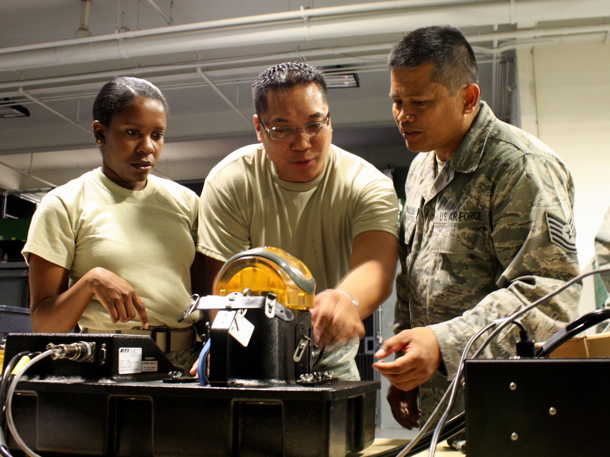 TRAVIS AIR FORCE BASE, Calif. -- Airman 1st Class Alivia Hampton, Tech Sergeant Emil Canlas, and Tech. Sergeant Bernardo Tinaliga, 349th Logistics Readiness Squadron, test gas masks during a routine leakage test here on August 5, 2011. (U.S. Air Force photo by Senior Airman Amelia Leonard)