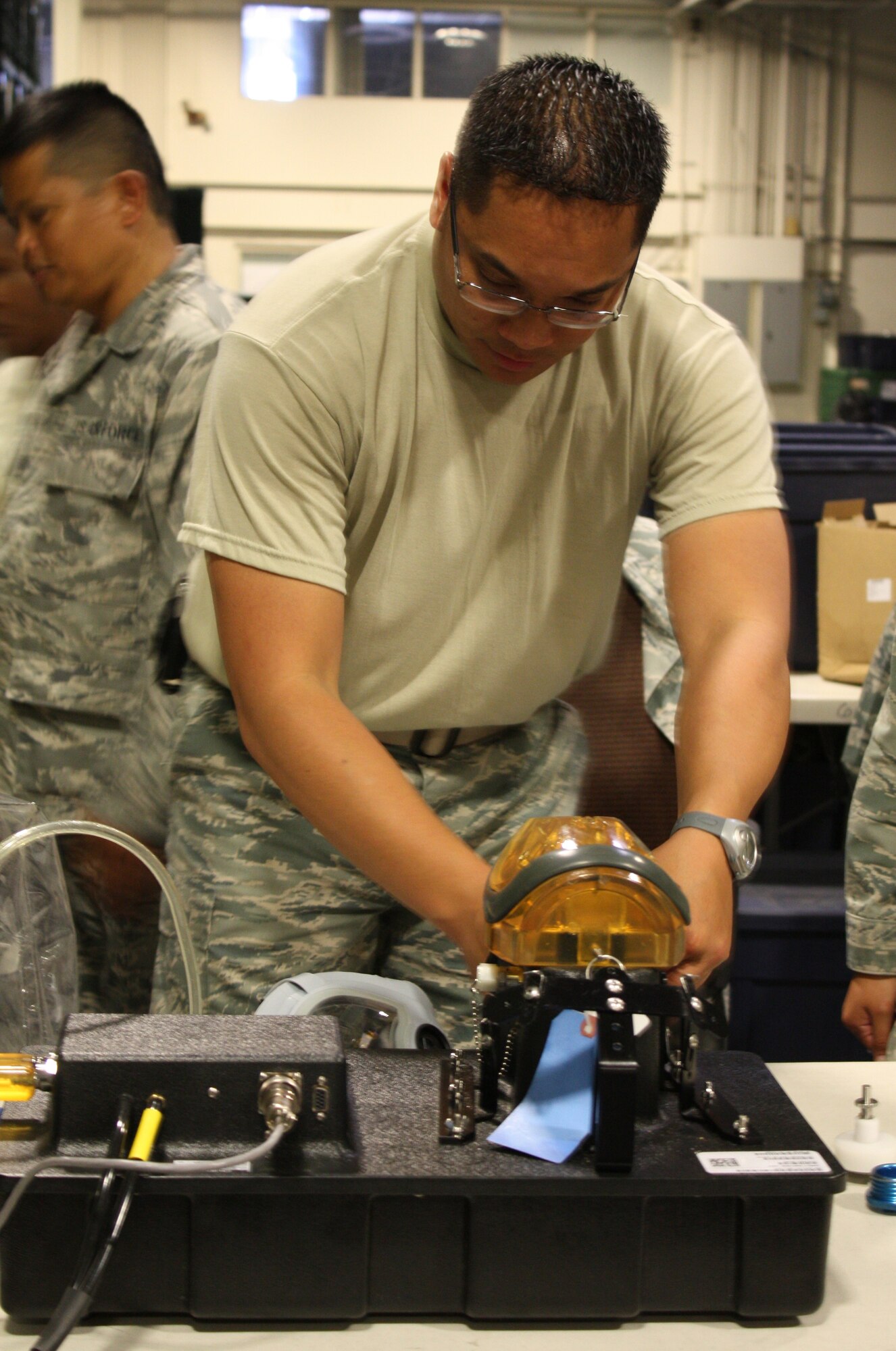 TRAVIS AIR FORCE BASE, Calif. -- Tech. Sergeant Emil Canlas, 349th Logistics Readiness Squadron, affixes a gas mask to an air pressure machine during a routine leakage test on August 5, 2011. (U.S. Air Force photo by Senior Airman Amelia Leonard)