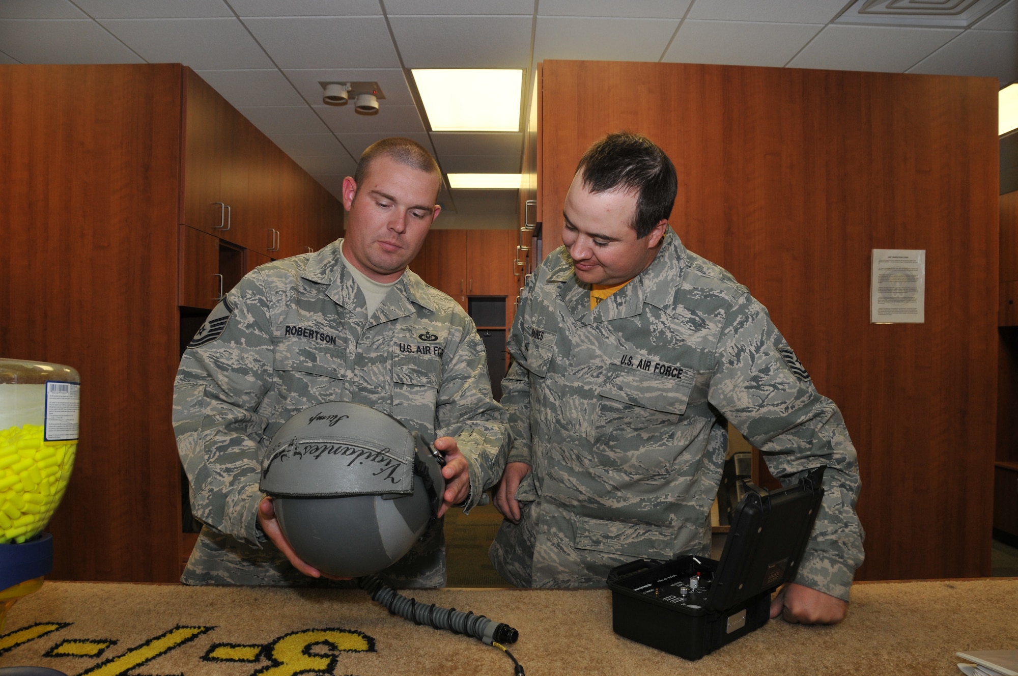 120th Fighter Wing Master Sgt. Raegen Robertson and Tech. Sgt. James Raines inspect a helmet during a post-flight check in the Aircrew Flight Equipment section on June 24, 2011. 
(U.S. Air Force photo by Senior Master Sgt. Eric Peterson.)