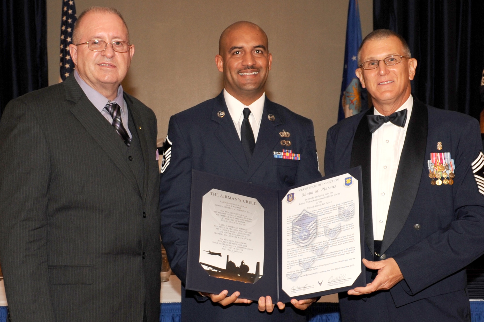 U.S. Air Force Master Sgt. Shaun Piernas is presented the Certificate of Induction by retired Chief Master Sgt. Larry Payne and Chief Master Sgt. Keith St. Aubin, 307th Bomb Wing (BW) command chief, during the Senior Noncommisioned Officer Induction Ceremony at Barksdale Air Force Base, La., Sept. 10, 2011. The ceremony is held annually to recognize newly promoted Master Sgts. within the 307th BW, 917th Fighter Group and the 307th Rapid Engineer Deployable Heavy Operations Repair Squadron Engineers. (U.S. Air Force photo by Master Sgt. Greg Steele/Released)