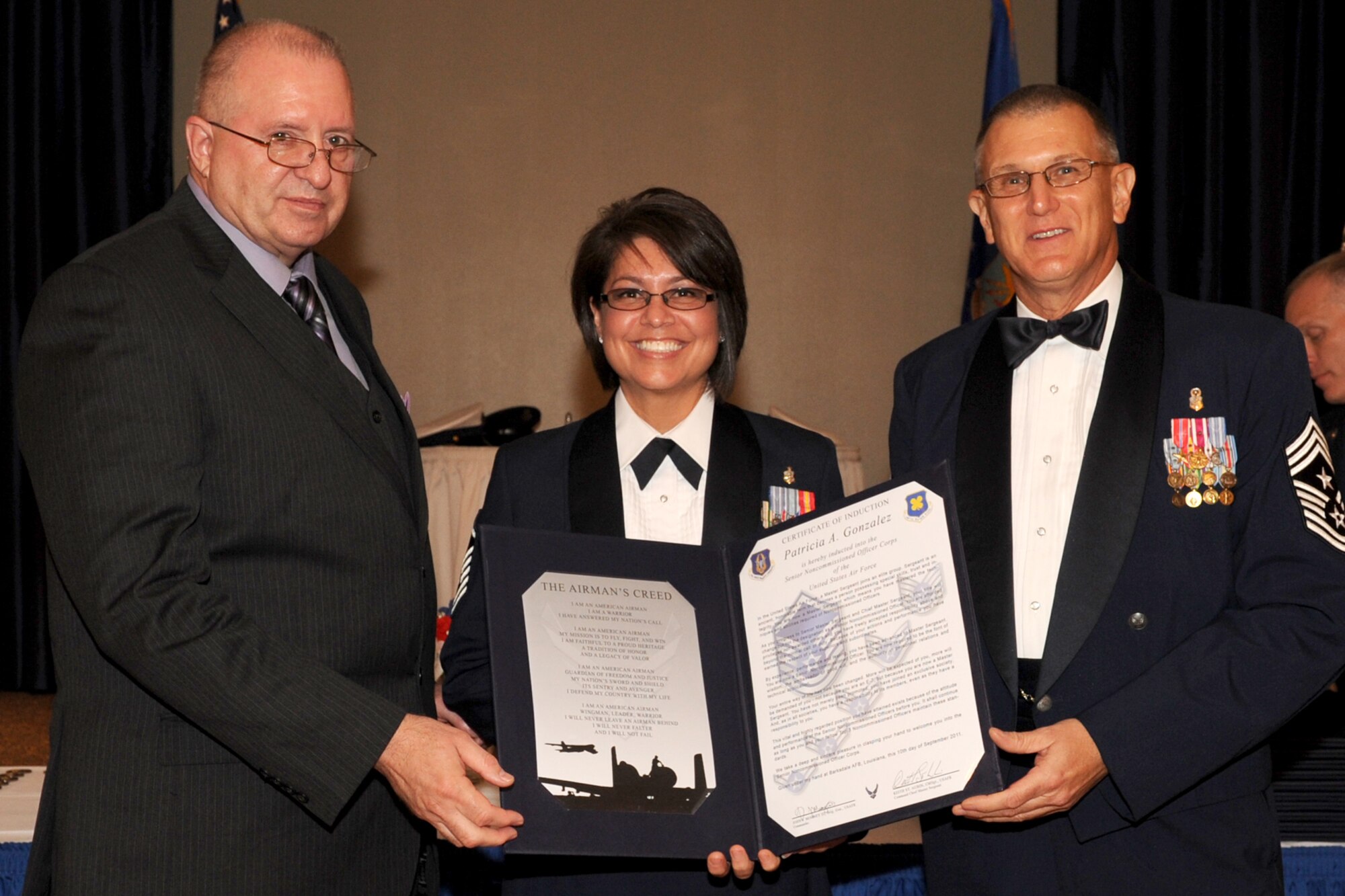 U.S. Air Force Master Sgt. Partricia Gonzales is presented the Certificate of Induction by retired Chief Master Sgt. Larry Payne and Chief Master Sgt. Keith St. Aubin, 307th Bomb Wing (BW) command chief, during the Senior Noncommisioned Officer Induction Ceremony at Barksdale Air Force Base, La., Sept. 10, 2011. The ceremony is held annually to recognize newly promoted Master Sgts. within the 307th BW, 917th Fighter Group and the 307th Rapid Engineer Deployable Heavy Operations Repair Squadron Engineers. (U.S. Air Force photo by Master Sgt. Greg Steele/Released)