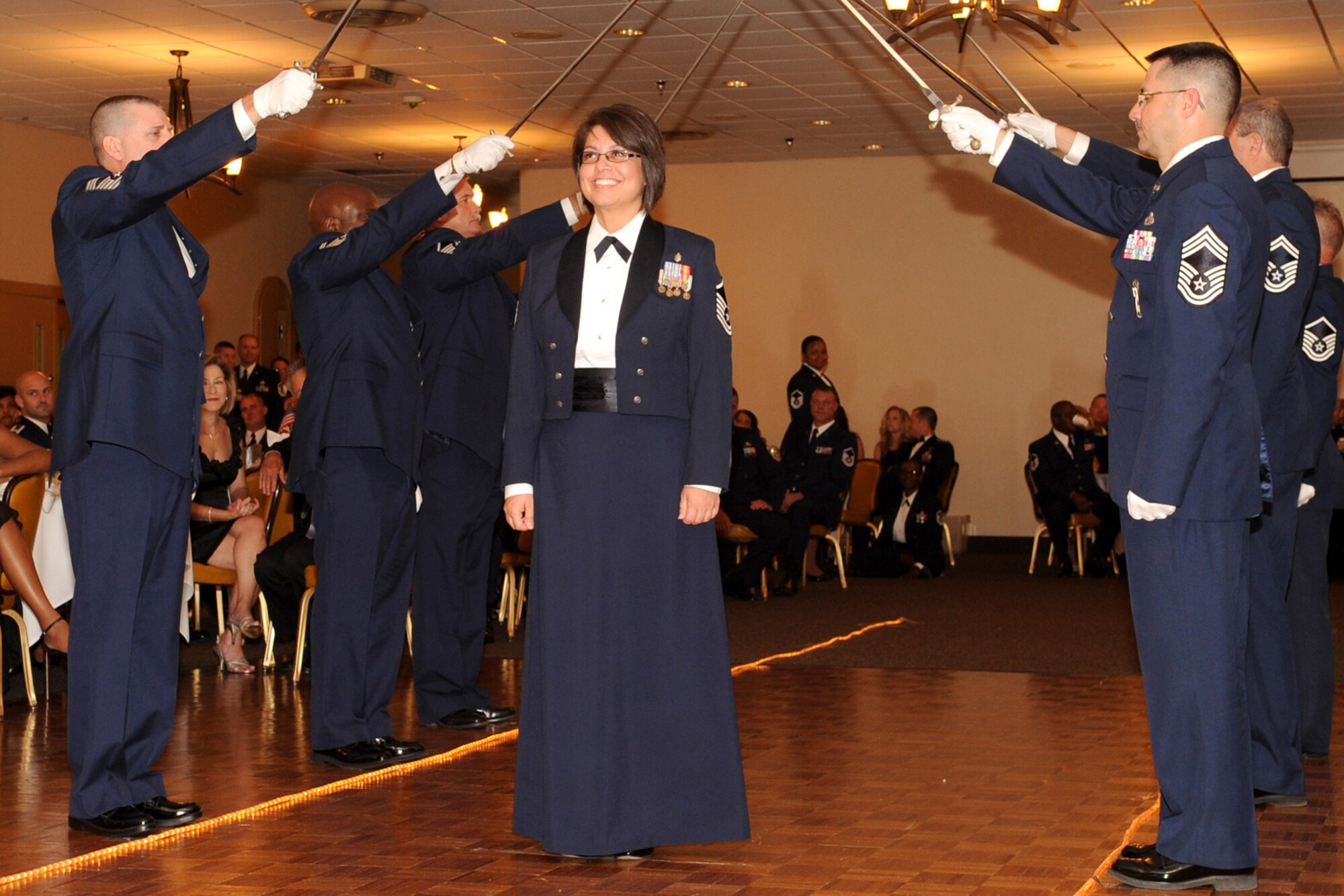 U.S. Air Force Master Sgt. Partricia Gonzales passes underneath a sword cordon during the Senior Noncommisioned Officer Induction Ceremony at Barksdale Air Force Base, La., Sept. 10, 2011. The ceremony is held annually to recognize newly promoted Master Sgts. within the 307th BW, 917th Fighter Group and the 307th Rapid Engineer Deployable Heavy Operations Repair Squadron Engineers. (U.S. Air Force photo by Master Sgt. Greg Steele/Released)