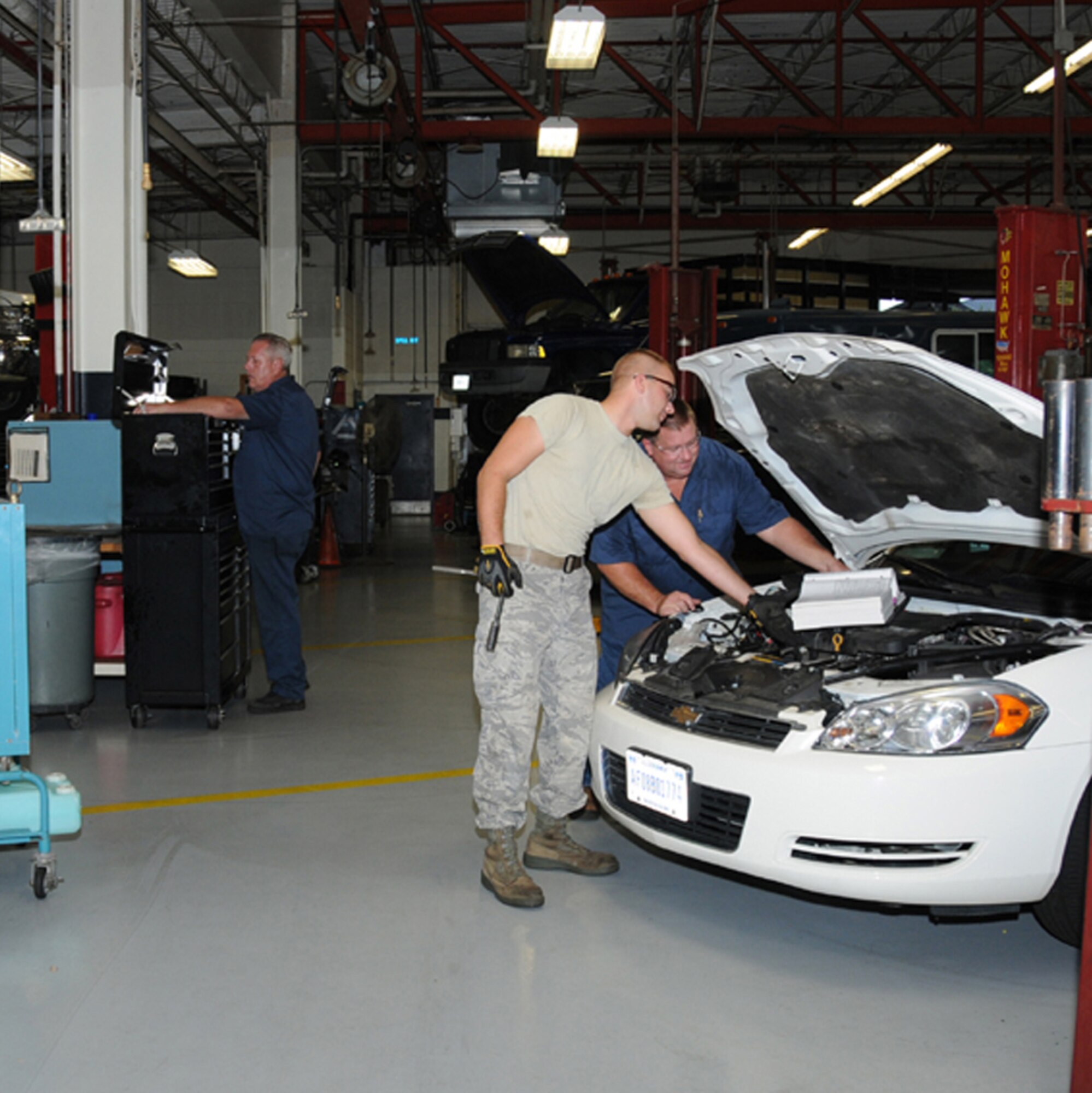 From left, Steve Cain, Senior Airman Matthew Chesnavage and Michael Rhodes,
81st Logistics Readiness Squadron, work in Keesler’s vehicle maintenance shop.
These days, maintenance and repair at Keesler are often accompanied by large
diagnostic manuals, testbooks for training and laptop computers that connect to onboard computers that tell the mechanic what’s wrong with the vehicle and how to fix it.  (U.S. Air Force photo by Kemberly Groue)