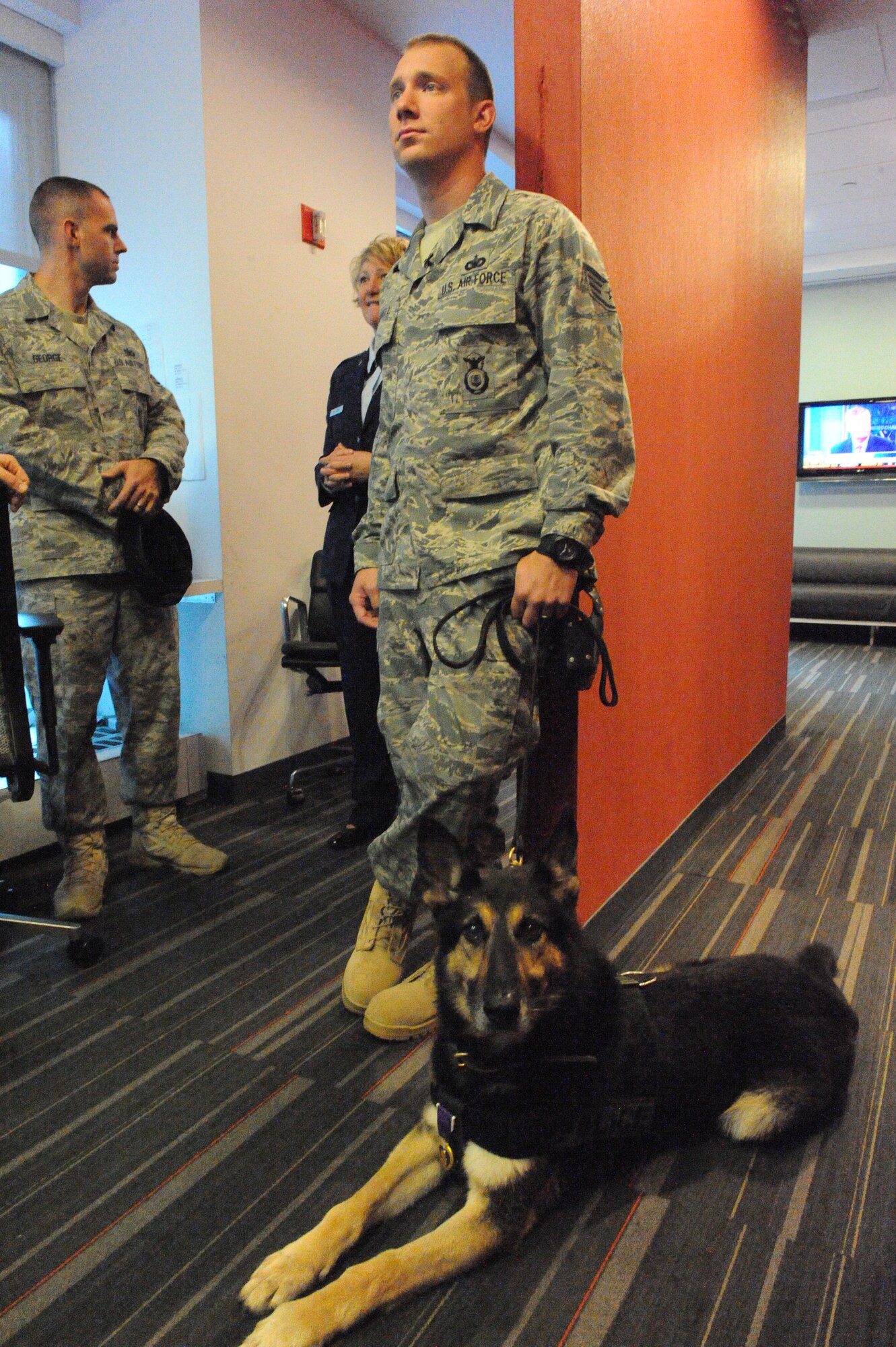 Staff Sgt. Benjamin Seekell watches the television monitors in the green room of the FOX and Friends studio in New York Sept. 12, 2011.  Seekell and his military working dog Charlie prepare to go on camera with other members of the 4th Security Forces Squadron from Seymour Johnson Air Force Base, N.C. to speak about the Security Forces 9/11 Ruck March to Remember.  Charlie wears the Purple Heart he was awarded after being injured by an improvised explosive device outside Bagram Airfield, Afghanistan on Mother’s Day 2011.  Charlie received shrapnel wounds to his hind quarters and damage to his eardrums and Seekell lost his left leg.  Seekell is a native of Charlestown, R.I. (U.S. Air Force photo by 2nd Lieutenant Keavy Rake)