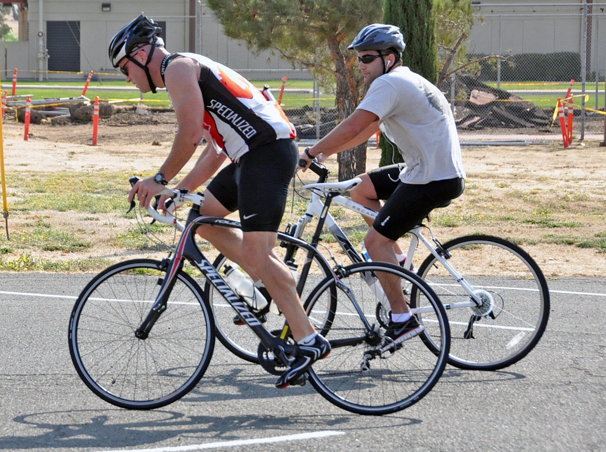 Competitors Maj. David Hammerschmidt, 60th Aircraft Maintenance Squadron commander, and Samuel Murray both begin the 12-mile cycling portion Saturday, after completing 10 laps in the pool. (U.S. Air Force photo/ Airman Madelyn Ottem)