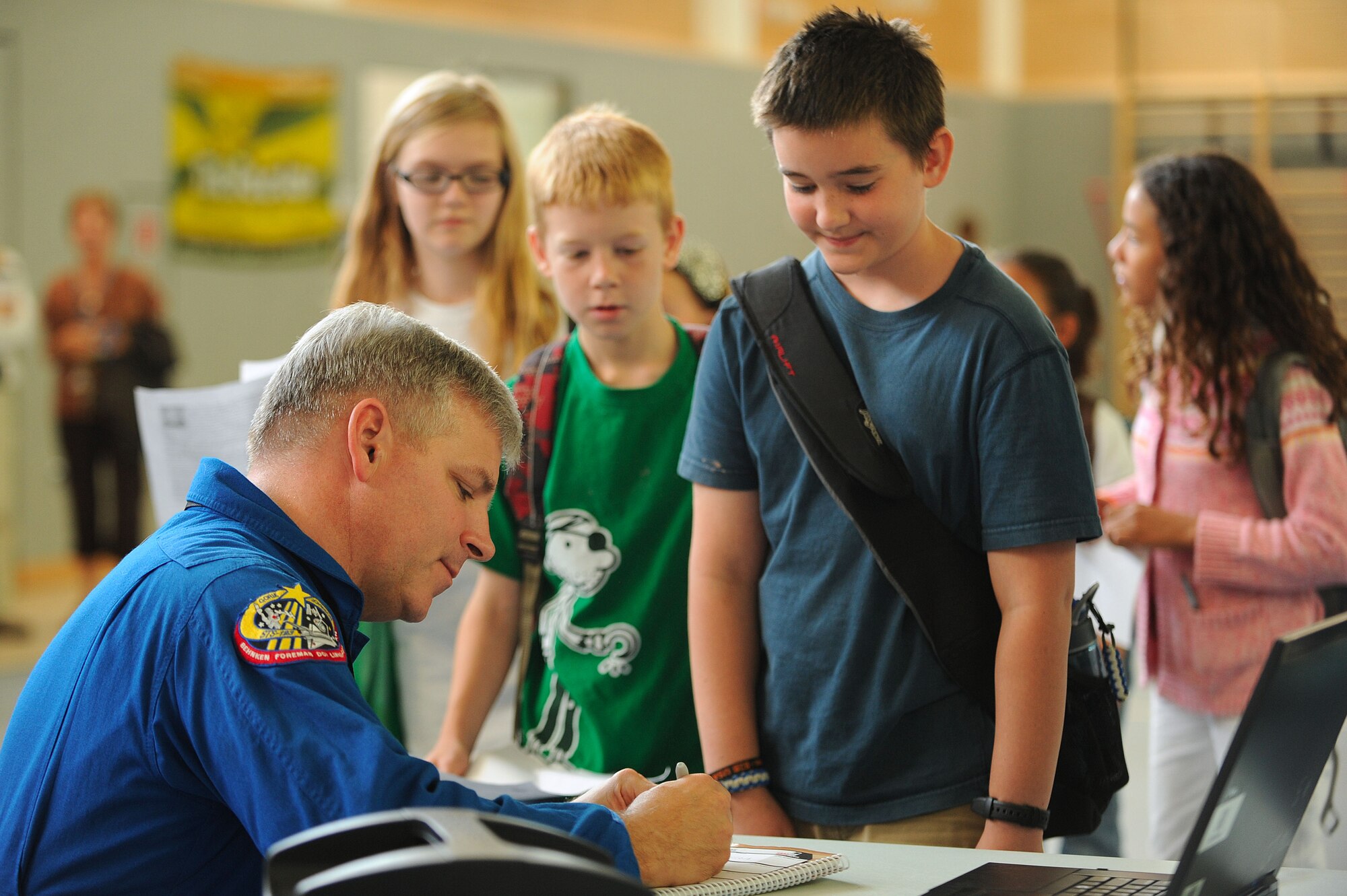 Gregory H. Johnson, NASA Astronaut, signs autographs for students, Ramstein Intermediate School, Ramstein Air Base, Germany, Sept. 15, 2011. Johnson has logged over 5,000 flight hours in more than 50 different aircraft and has flown two shuttle missions. (U.S. Air Force photo by Senior Amn Stephen J. Otero)