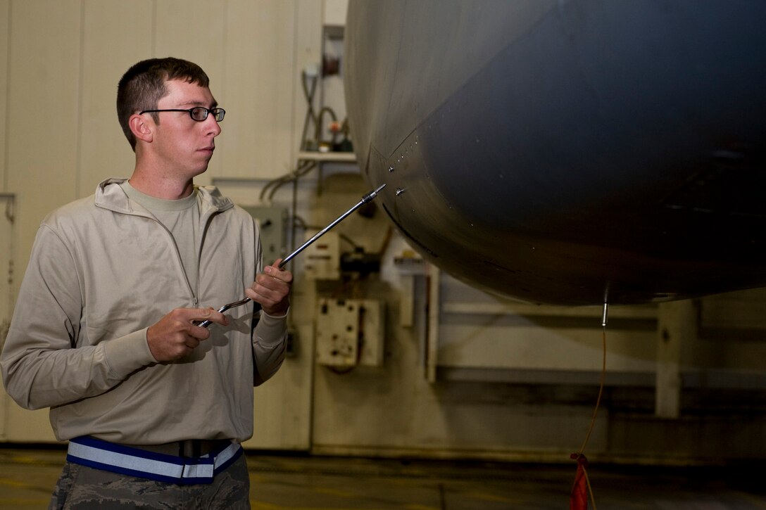 Senior Airman Chris Orr, 37th Aircraft Maintenance Unit electrical and environmental specialist, unscrews bolts on a panel attached to a B-1B Lancer on Ellsworth Air Force Base, S.D., Sept. 14, 2011. More than 130 Airmen of the AMU supported 585 air tasking orders during their deployment with the 379th Air Expeditionary Wing from Jan. through July 2011 without dropping a single one (U.S. Air Force photo by Airman Alystria Maurer/Released)