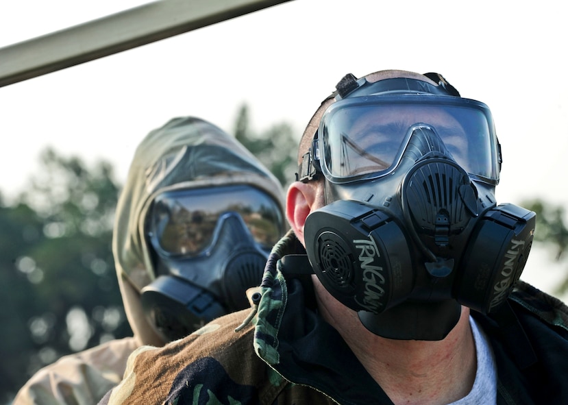 U.S. Air Force Tech. Sgt. Charles Bell, 23rd Civil Engineer Squadron water systems and fuel maintenance NCO in charge, removes his chemical warfare top with the help of Airman 1st Class Paul Francis, 23rd Wing public affairs photographer, during contamination control area attendant training, at Moody Air Force Base, Ga., Sept. 14, 2011. The training taught the attendants what to look for when processing Airmen through the contamination control area. (U.S. Air Force photo by Senior Airman Stephanie Mancha/Released)