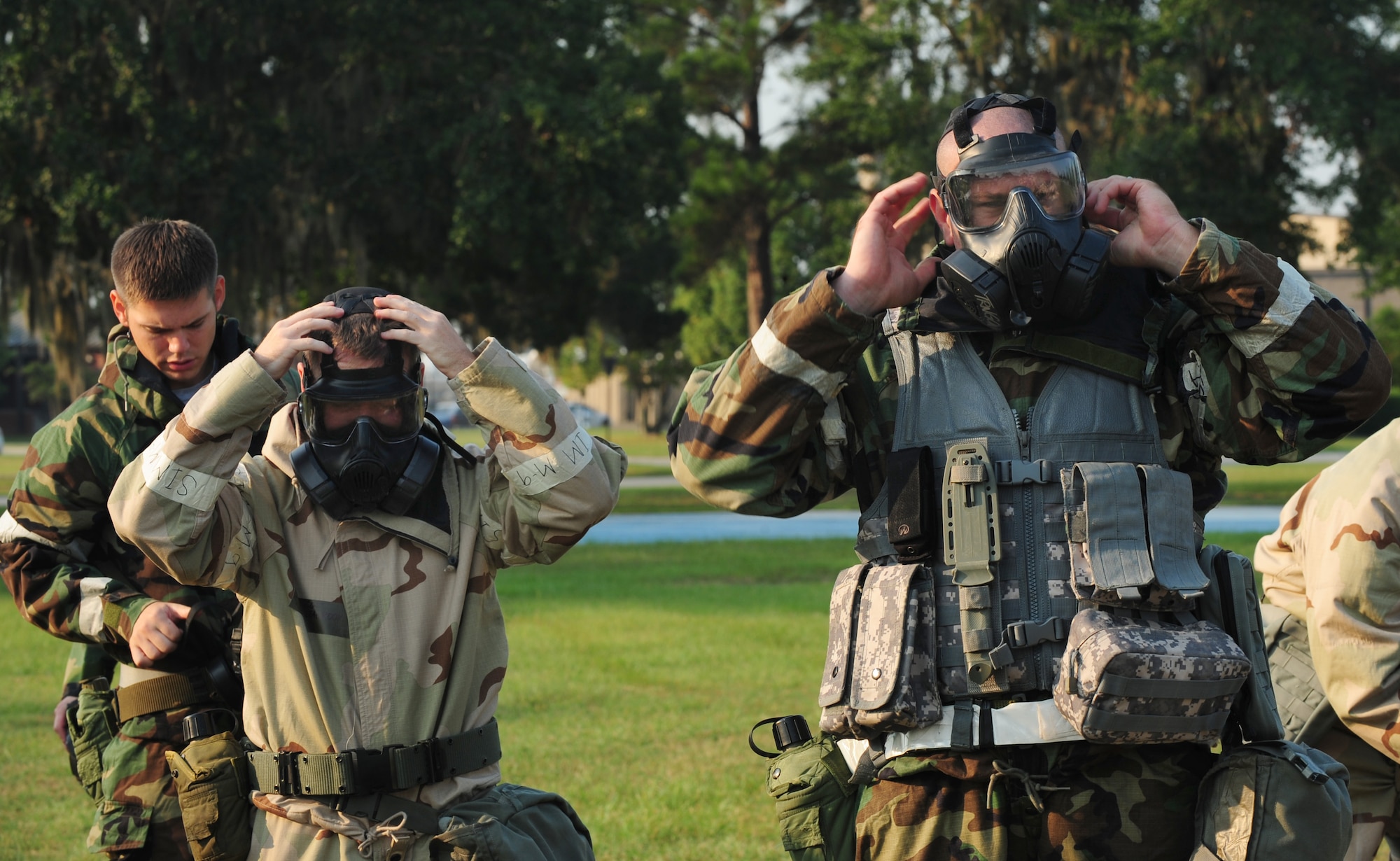 U.S. Air Force Tech. Sgt. Charles Bell, 23rd Civil Engineer Squadron water systems and  fuel maintenance NCO in charge, right, and Staff Sgt. David Seabrook, 347th Operation Support Squadron aircrew flight equipment craftsman, get into mission-oriented protective posture level four before going through the contamination control area (CCA) at Moody Air Force Base, Ga., Sept. 14, 2011. After being trained on the different stations of the CCA the attendants went through area to get a better feel of the decontamination process.  (U.S. Air Force photo by Senior Airman Stephanie Mancha/Released)