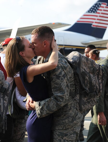 U.S. Air Force Senior Airman Joshua Tesch, 77th Fighter Squadron crew chief, kisses his girlfriend Jessica Haas at Shaw Air Force Base, S.C. Sept. 14, 2011. The 77th Fighter Squadron returned from a five month deployment after providing air suppression and destruction of enemy defenses in support of Operation Unified Protector. (U.S. Air Force photo by Airman 1st Class Tabatha Duarte/Released)