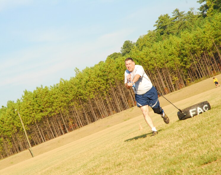 Lt. Col. David Rodberg, flight commander of the 94th Aeromedical Evacuation Squadron, perseveres as the clock dwindles down during a 30-second tire-run, completed as part of circuit training held Sept. 14. Participants alternated between exercises at 15 to 30-second intervals during the hour-long Fit Camp. (U.S. Air Force photo/Airman 1st Class Chelsea Smith)