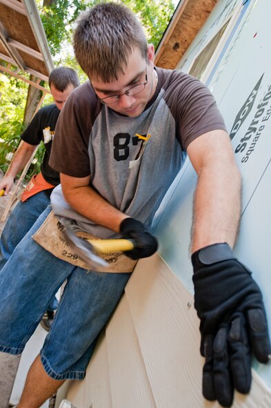 U.S. Air Force Airman 1st Class Jerry Michaels, 23rd Communication Squadron, hammers a nail into a wall siding during a Habitat for Humanity build in Valdosta, Ga., on Sept. 13, 2011. Michaels and fellow Team Moody members volunteered their free time to aid with the build which will provide a home for Tim and Miranda Mabry and their three children, as well as Tim’s mother, Carol Cooper.  (U.S. Air Force photo by Staff Sgt. Joshua J. Garcia/Released)