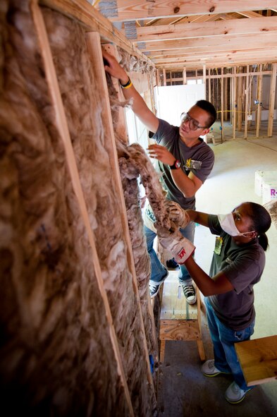 U.S. Air Force Senior Airman Christopher Canlas, and U.S. Air Force Master Sgt. Sherwon Bennett, both from the 23rd Mission Support Group, put insulation into the wall frame during the Habitat for Humanity build, in Valdosta Ga., on Sept. 13, 2011Habitat for Humanity has helped build over 400,000 affordable houses and served more than 2 million people around the world. (U.S. Air Force photo by Staff Sgt. Joshua J. Garcia/Released)
