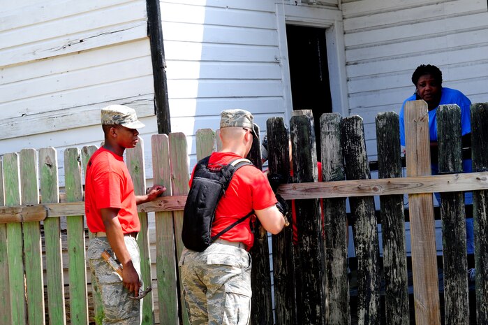A resident of one of the homes under going maintenance watches as two volunteers fix her fence during National Day of Caring, Sept. 9, 2011, in the East Central neighborhood of Charleston, S.C.  More than 200 volunteers participated in 35 projects which included landscaping, debris removal, painting, and light repairs in neighborhoods located in downtown Charleston.  Military, DoD, civilians, dependents and retirees participated in the community service project. (U.S. Air Force photo/Staff Sgt. Nicole Mickle)