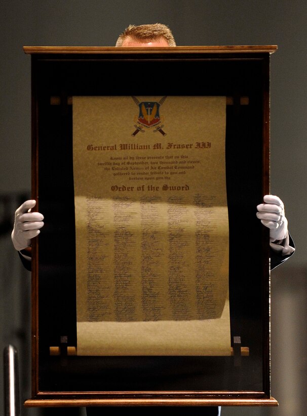 U.S. Air Force Command Chief Master Sgt. Kevin Howell, 633rd Air Base Wing, presents the scroll to the audience during the Order of the Sword Ceremony Sept. 12, 2011, in Hampton, Va. The scroll was signed by all Airmen in attendance  and presented to Gen. William M. Fraser III, commander of Air Combat Command, for his outstanding military leadership. (U.S. Air Force photo by Staff Sgt. Dana Hill/Released)