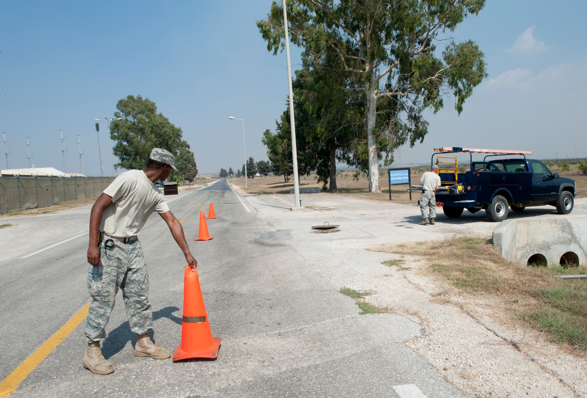 Airman 1st Class Kendall Armand, 39th Communications Squadron cable and antenna system maintenance journeyman, sets traffic cones around a confined space cable entry hole Sept. 14, 2011, at Incirlik Air Base, Turkey. With cable maintenance Airmen having more than 600 miles of cable to check and maintain, most of which is underground, these entry points allow them to access the underground cables without having to dig them up. (U.S. Air Force photo by Senior Airman Anthony Sanchelli/Released)
