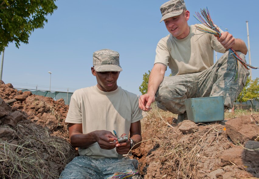 Staff Sgt. Scott Gingrich, 39th Communications Squadron cable and antenna system maintenance craftsman, right, and Airman 1st Class Kendall Armand, 39th CS cable and antenna system maintenance journeyman, splice together new wiring in a buried cable line Sept. 14, 2011, at Incirlik Air Base, Turkey. The cables are spliced with new wiring when older wires are damaged or cut. (U.S. Air Force photo by Senior Airman Anthony Sanchelli/Released)