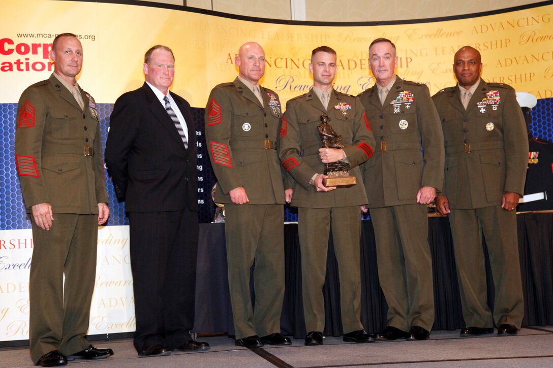 Capt. Tyson M. Ackerman receives the Lt. Col. Michael D. Kuszewski Marine Corps Intelligence Officer of the Year Award from Gen. Joseph F. Dunford, assistant commandant of the Marine Corps, at the first Marine Corps Association Intelligence Award Dinner Sept. 15, 2011 in Arlington, Va. Four Marines and one civilian were recognized for excellent work in Marine Corps intelligence. The awards are named after Marines who have served the intelligence community.