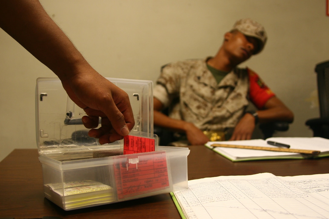 Cpl. Roy A. Covington III, a station air traffic controller, pretends to falls asleep as another Marine pretends to steal a red card while covering a Duty Non-Commissioned Officer post at Headquarters and Headquarters Squadron barracks 314 Sept. 16 in order to show the importance of Operational Security. DNCO post is a 24 hour responsibility given to NCOs in order for barracks to be secured and gaurded at all times.