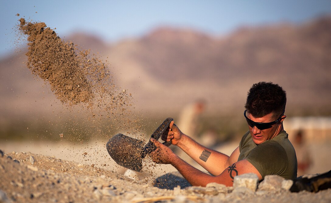 Cpl. Richard Mikesell, a squad leader with Kilo Company, 3rd Battalion, 3rd Marine Regiment, digs in a machine gun position during Exercise Clear, Hold, Build 2 on Marine Corps Air Ground Combat Center Twentynine Palms, Calif., Sept. 16, 2011. The battalion’s line companies — India, Kilo and Lima — each arrived by helicopters or tracked vehicles to clear enemy activity from the village, establish security and re-build rapport with local nationals. During the Enhanced Mojave Viper training exercise here, the Marines of “America’s Battalion” are training to kill enemy fighters by practicing counterinsurgency operations. Next month, they’ll deploy to Afghanistan’s Helmand province to support Operation Enduring Freedom. Mikesell, 23, is from Chubbuck, Idaho.