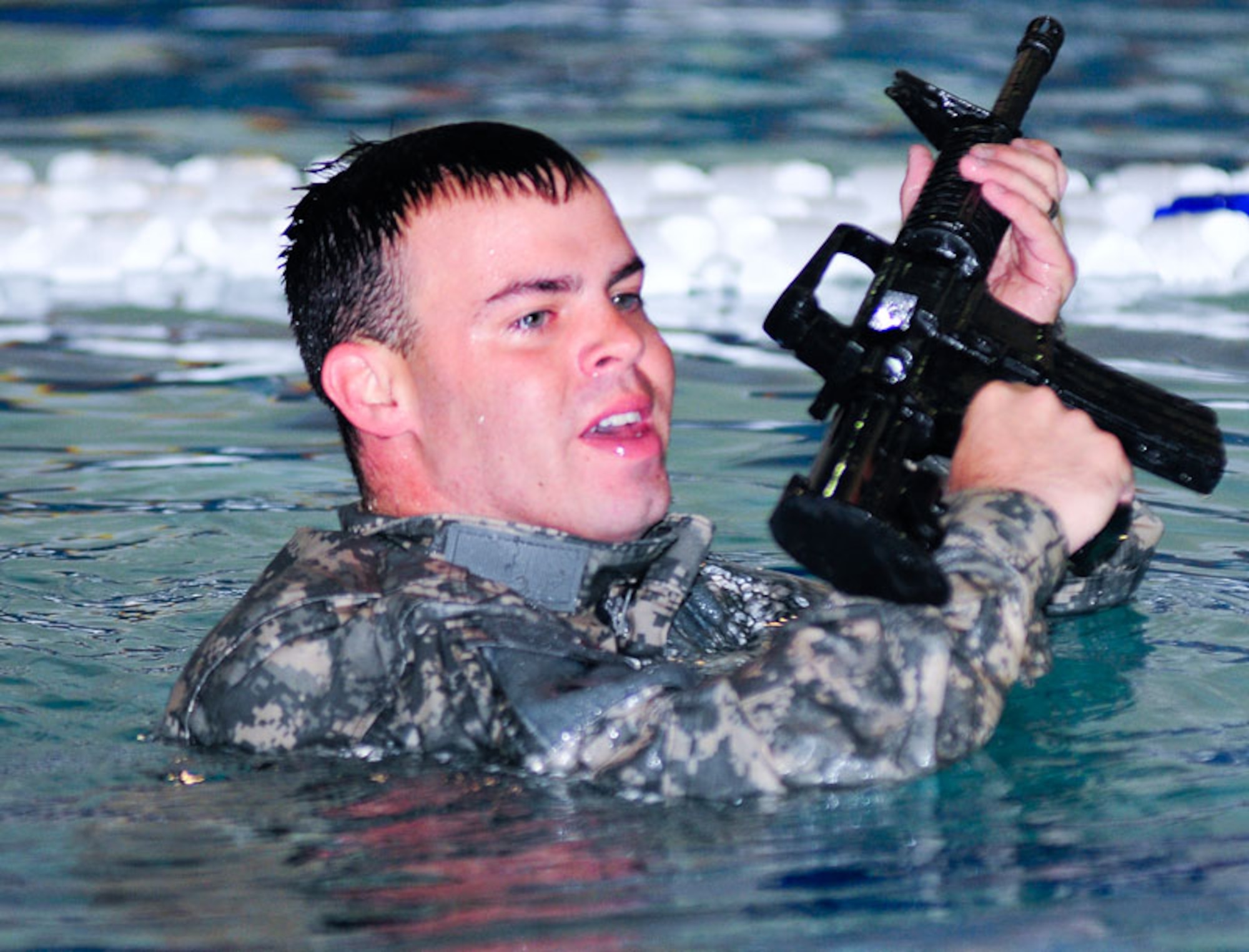 Sgt. James Ewald begins a 25-meter swim with his M4 carbine.  (U.S. Air Force photos/Percy G. Jones)