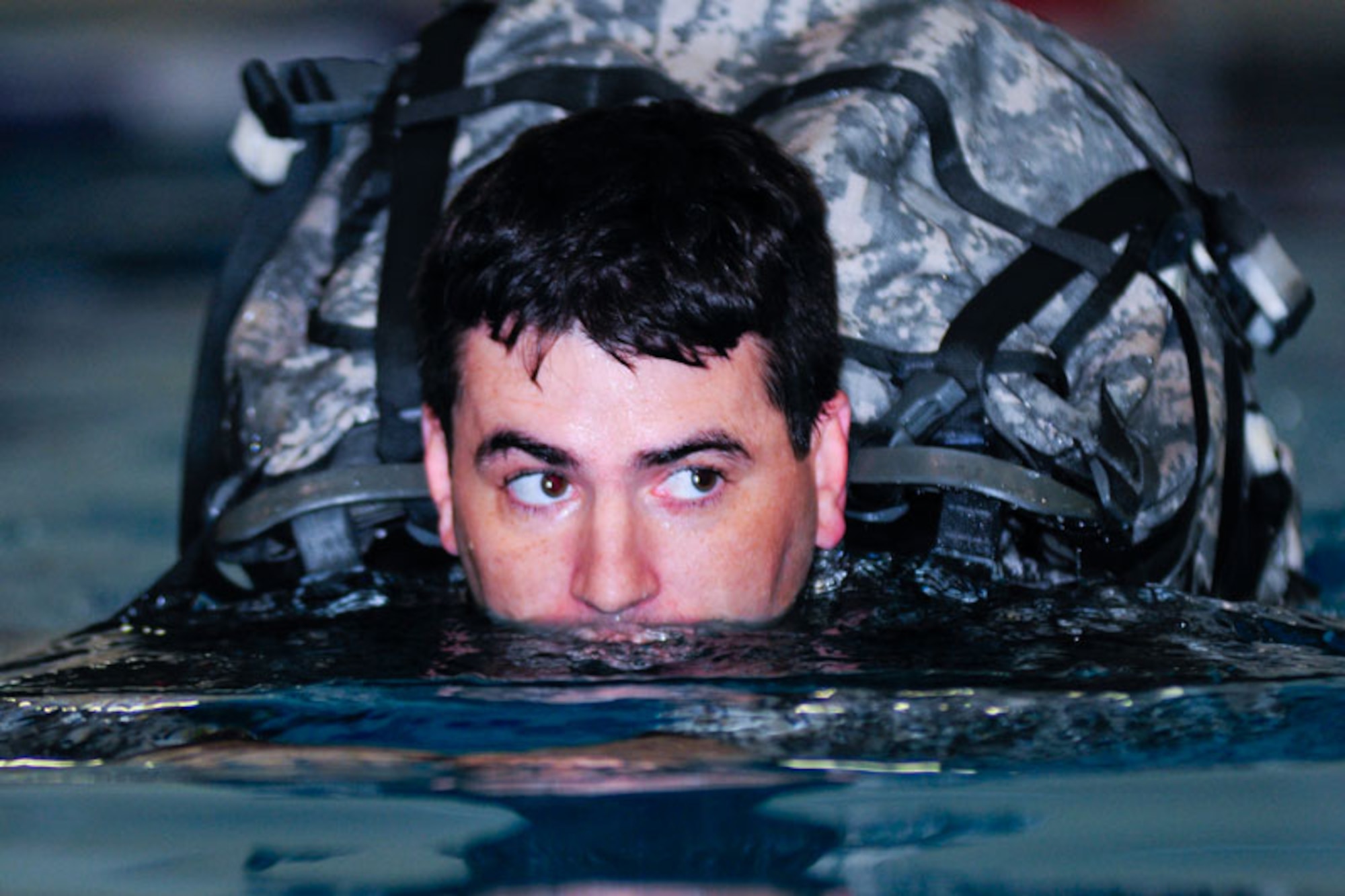 Sgt. William Guindon, 4th Quartermaster Detachment (Airborne), completes a 25-meter swim with his rucksack. The company’s combat water survival training at Buckner Physical Fitness Center, Sept. 1, included treading water for five minutes, completion of two separate 25-meter swims – one with rucksack and then M-4 Carbine – making of flotation devices from the Army Combat Uniforms and a three-meter platform dive and 25-meter swim with their weapons.  (U.S. Air Force photos/Percy G. Jones)