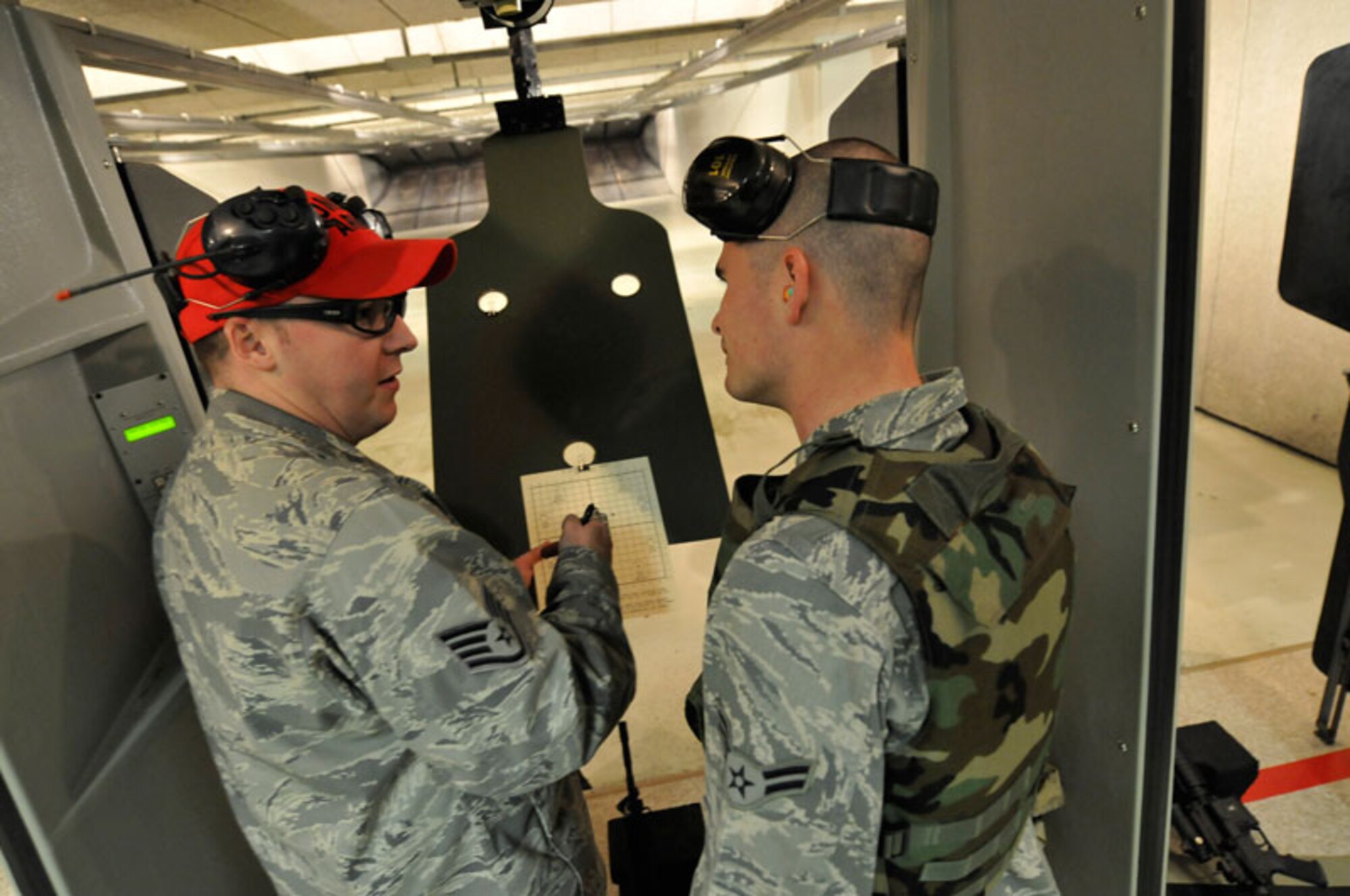 SSgt Rodney Parson, 673 ABW/SFLC scores A1C Jermey Millers', 673 ABW/LRS, Joint Base Elmendorf-Richardson, Anchorage, Alaska, target during annual weapons training on a M-4A1 carbine. The 7 hour training includes qualifying at the indoor range, weapon handeling, safety,  and weapons cleaning.     (U.S. Air Force photo/Steve White)
