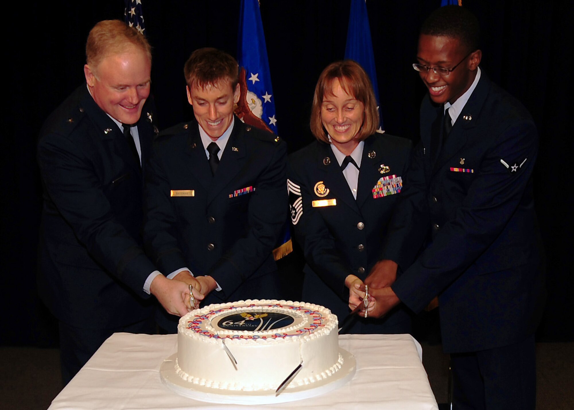 Brig. Gen. Roger Teague, SMC vice commander, and Chief Master Sgt. Vicki Robinson are joined by Los Angeles AFB’s youngest officer and enlisted members for the ceremonial cake cutting marking the Air Force’s 64th birthday, Sept. 16. (Photo by Jim Gordon)