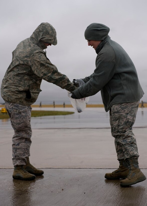 Staff Sgt. Matthew Griffith and Tech. Sgt. Sarah Robson of the 28th Civil Engineer Squadron technical support flight, remove Foreign Object Debris from the flightline during a FOD walk on Ellsworth Air Force Base, S.D., Sept. 15, 2011. Groups of Airmen walked the runway and taxiways to ensure the area was free from any debris that could cause damage to aircraft. (U.S. Air Force photo by Airman 1st Class Kate Thornton/Released)