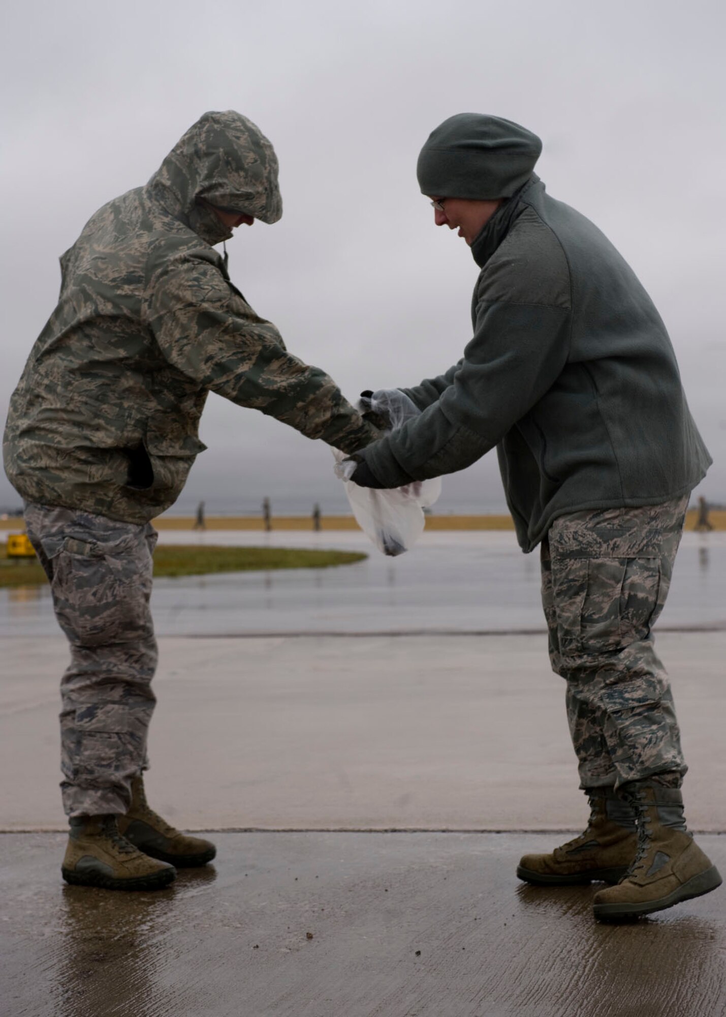 Staff Sgt. Matthew Griffith and Tech. Sgt. Sarah Robson of the 28th Civil Engineer Squadron technical support flight, remove Foreign Object Debris from the flightline during a FOD walk on Ellsworth Air Force Base, S.D., Sept. 15, 2011. Groups of Airmen walked the runway and taxiways to ensure the area was free from any debris that could cause damage to aircraft. (U.S. Air Force photo by Airman 1st Class Kate Thornton/Released)
