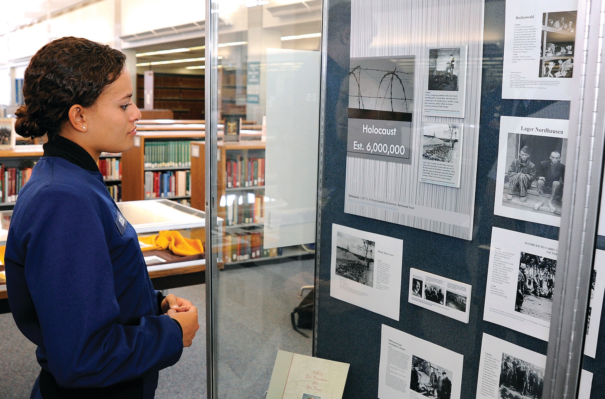 The genocide exhibit in The Air Force Academy's McDermott Library catches the eye of Cadet 4th Class Athina Teicher. (U.S. Air Force Photo/Mike Kaplan)