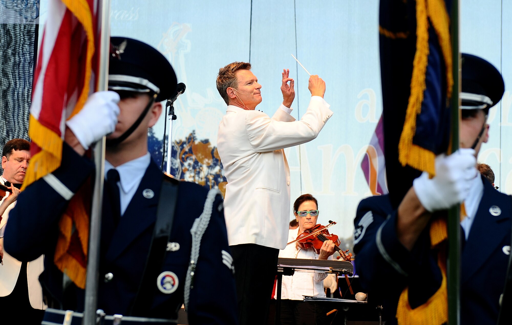 Ernest Richardson, the resident conductor of the Omaha Symphony, leads the ensemble as the Offutt Air Force Base Honor Guard posts the colors to begin A Celebration of American Spirit memorial concert at Turner Park in Omaha, Neb., Sept. 11.  The concert was collaboration between the U.S. Air Force's Heartland of America Band and the Omaha Symphony on the 10-year anniversary of 9/11. (U.S. Air Force photo by Josh Plueger/Released)