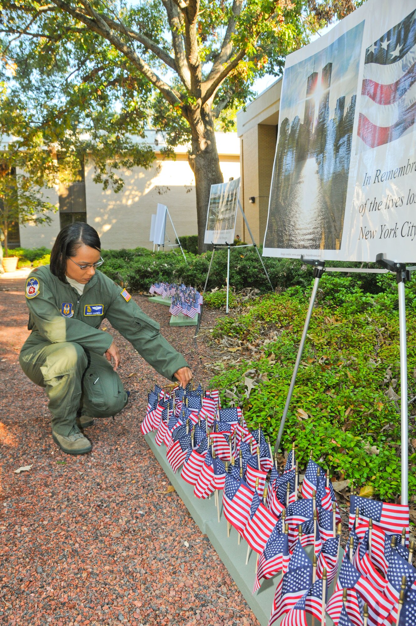 Air Command and Staff College student Maj. Mary Carnes places a flag in display paying tribute to those lost on Sept. 11. (Air Force photo/Chris Baldwin)