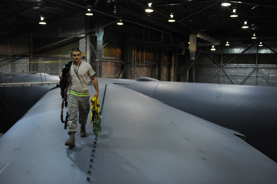 Staff Sgt. Joshua Partin, 2nd Maintenance Squadron Fabrication Flight, carries harnesses across the wing of a B-52H Stratofortress in a hangar on Barksdale Air Force Base, La., Sept. 12. Airmen from the fabrication flight respond to calls from other maintenance Airmen throughout the night to fabricate parts for B-52Hs. (U.S. Air Force photo/Airman 1st Class Micaiah Anthony)(RELEASED)