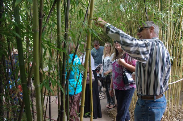 Stan Schug, horticulture curator, right, informs members of the Kirtland Officers Spouses Club about the numerous types of bamboo able to grow in a desert climate.