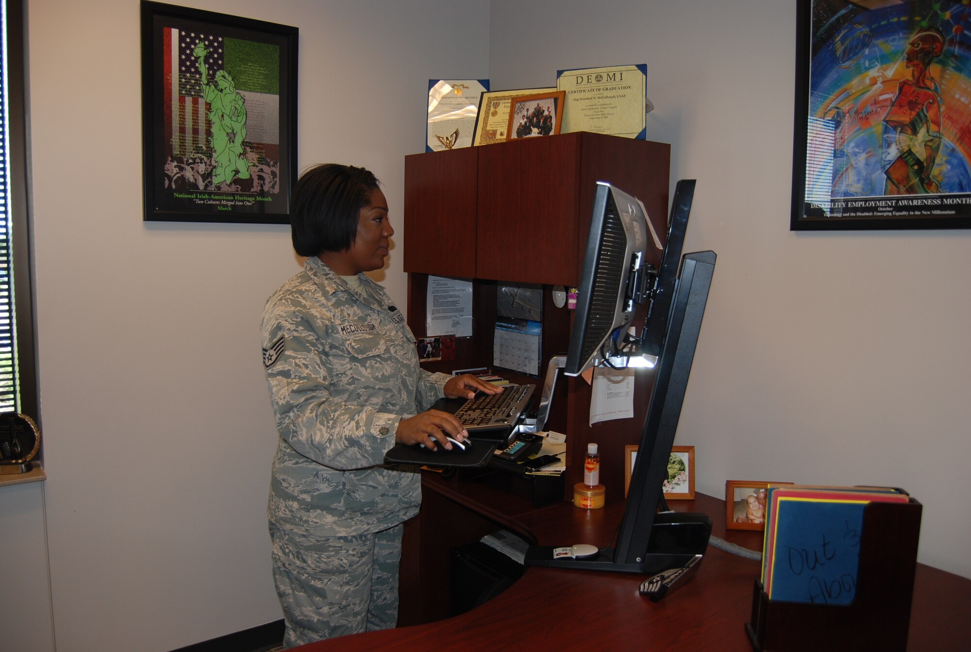 Staff Sgt. Rooshell McCullough, 21st Space Wing Equal Opportunity Office, works at her stand up desk station. These stations were purchased in an effort to promote better health in the work place. Standing at work can help ease back pain and increase a person’s metabolic rate. (U.S. Air Force photo/Lea Johnson)