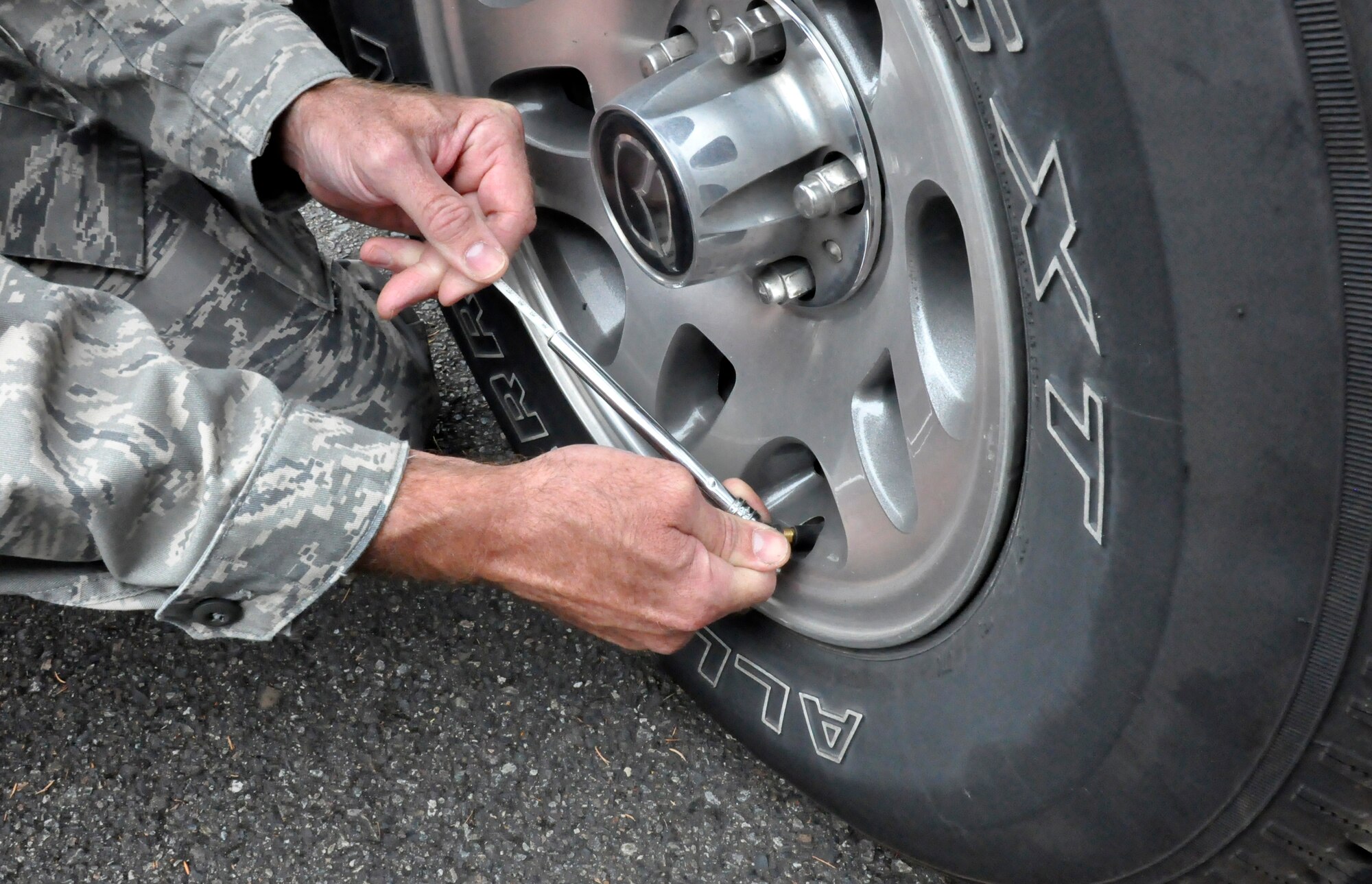 A Reservist from the 446th Airlift Wing Safety Office, McChord Field, Wash., uses a tire pressure gage to check the tire pressure on a vehicle, Sept. 11, 2011.  A tire pressure gage is one item that should be included in an emergency supply kit for personal vehicles, according to the safety office. With the fall and winter months coming up, keeping an emergency supply kit should be used in the case of, vehicle accidents, being stranded in bad weather or remote locations, vehicle breakdowns, long-distance travel, or helping others who need assistance. The safety staff recommends kits like these are stored in a backpack for easier mobility. (U.S. Air Force photo by Master Sgt. Jake Chappelle) 