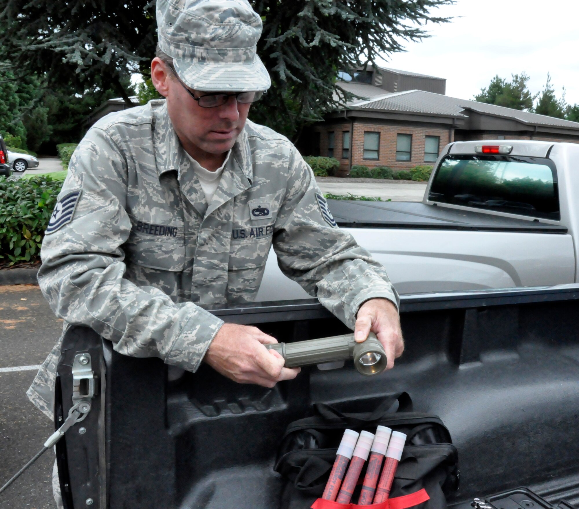 U.S. Air Force Tech. Sgt. David Breeding, 446th Airlift Wing Safety Office, McChord Field, Wash., displays a flashlight as he goes through the basics of what should be included in a vehicle emergency supply kit, Sept. 15, 2011. Breeding suggests these kits should available in the case of, vehicle accidents, being stranded in bad weather or remote locations, vehicle breakdowns, long-distance travel, or helping others who need assistance. Breeding says the kits should be stored in a backpack for easier mobility. (U.S. Air Force photo by Master Sgt. Jake Chappelle)