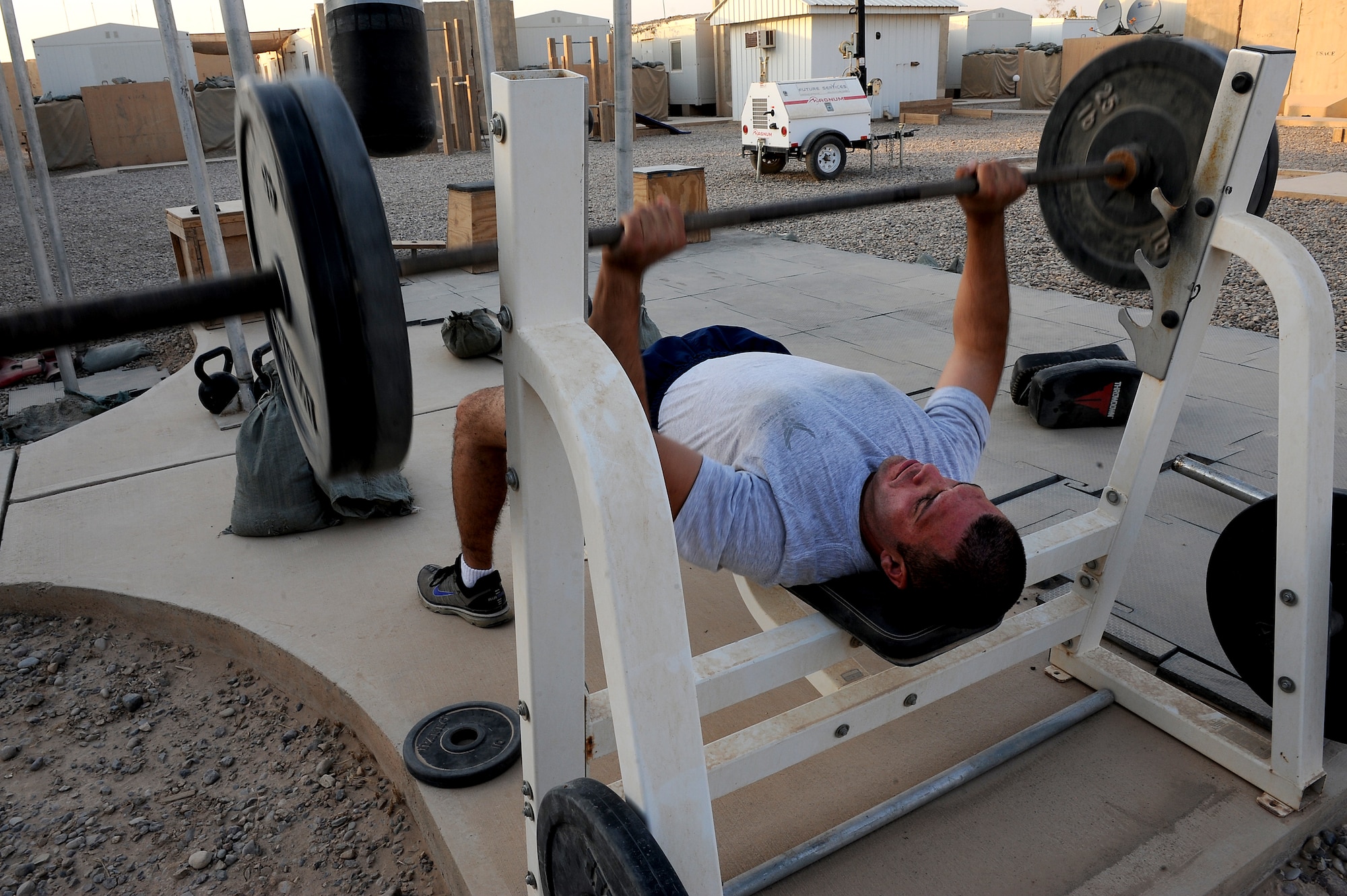 Staff Sgt. Joe Cardiel, 52nd Expeditionary Flying training Squadron, Camp Speicher, Iraq, works out at the "prison yard" after a day at work. The NCO is an aircrew flight equipment specialist, deployed from El Paso, Texas. He is responsible for training Iraqi air force AFE specialists. He is deployed from the 2nd Operations Support Squadron at Barksdale Air Force Base, La. (U.S. Air Force photo/Staff Sgt. Mike Meares)