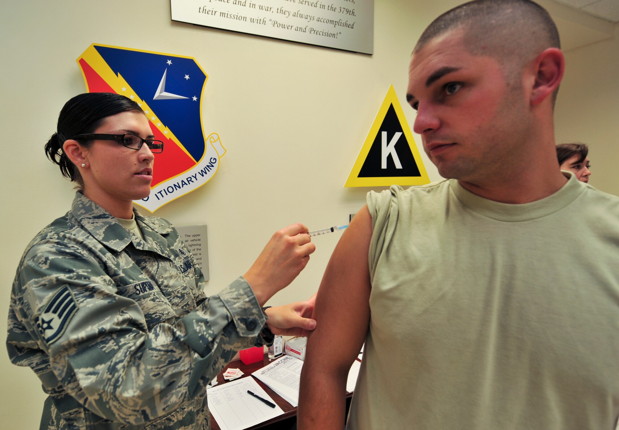 SOUTHWEST ASIA -- Staff Sgt. Angela Supina, 379th Expeditionary Medical Group medical technician, administers a flu vaccine to Staff Sgt. Charles Thompson, 379th Air Expeditionary Wing command post, Sept. 13, 2011, in preparation for the upcoming flu season. Flu shots are now available to base personnel. Supina, a native of Ashford, Conn., is deployed from Joint Base Elmendorf-Richardson, Alaska. Thompson, a Cocoa, Fla., native, is deployed from Sheppard Air Force Base, Texas.  (U.S. Air Force photo/Senior Airman Paul Labbe)