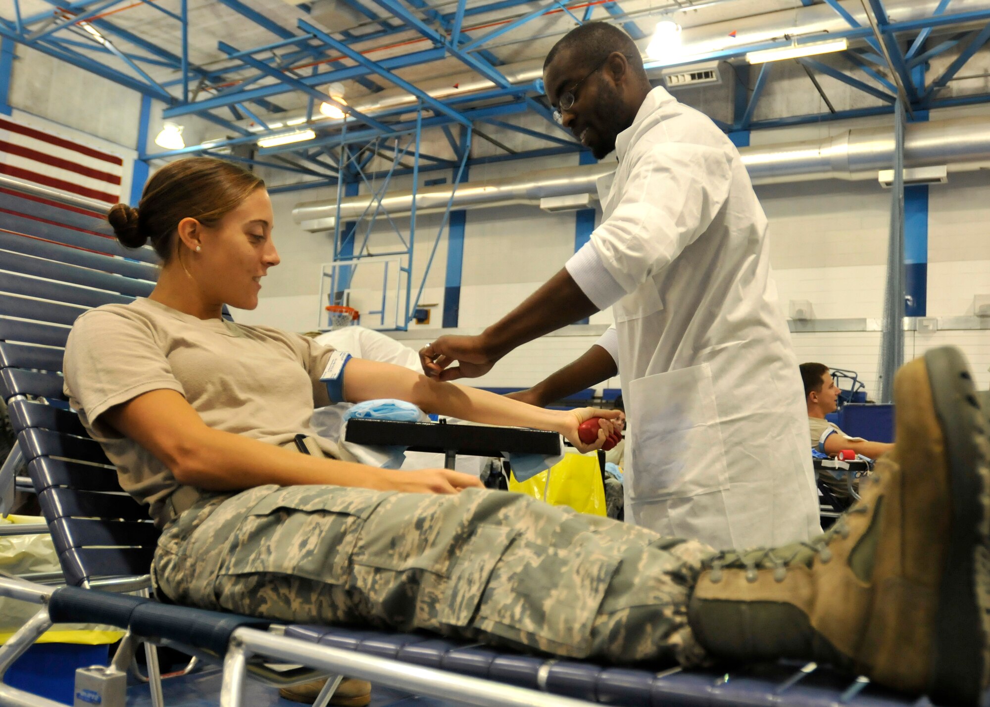 ROYAL AIR FORCE LAKENHEATH, England - Leonard Little, Longstuhl Regional Medical Center medical laboratory technician checks the arm of Airmen 1st Class Sarah Harnitche, 48th Operational Support Squadron air traffic controller, for a usable vein during a blood drive at the fitness center, Sept. 14, 2011. More than 250 people attended, amounting to 85.5 liters of blood donated. (U.S. Air Force photo by Senior Airman Tiffany M. Deuel)