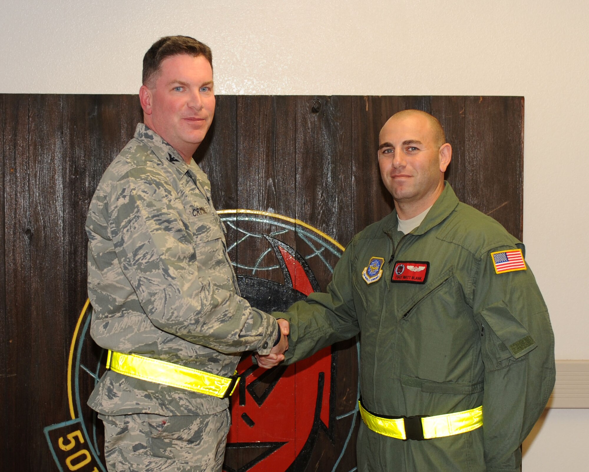 Col. Thomas Crimmins, 19th Airlift Wing vice commander, presents a commander’s coin to Tech. Sgt. Matthew Blank, a 50th Airlift Squadron evaluator flight engineer Sept. 15, 2011, at Little Rock Air Force Base, Ark. Blank led Dyess Air Force Base C-130H3 upgrade training, performed 64 hours of ground training, and spent six flight hours training nine flight engineers, enabling them to fly on multiple types of C-130’s. (U.S. Air Force Photo by Senior Airman Caleb Pierce)