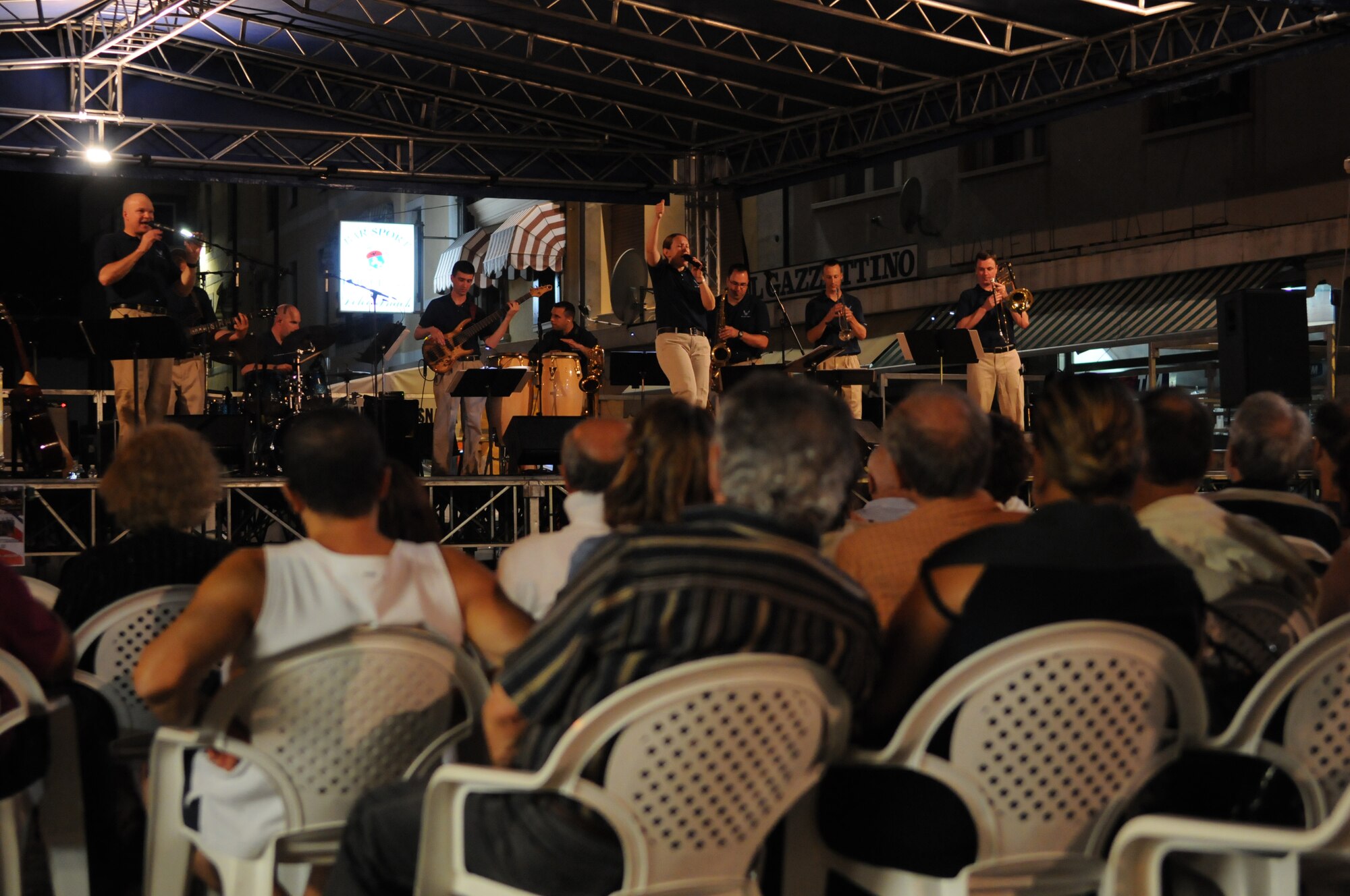Members of the Aviano community listen to a performance by the band “Direct Hit," an eight member rock ensemble made up of musicians from the United States Air Forces in Europe Band, Sept. 15 in the Aviano town square. Direct Hit is one of USAFE's popular music ensembles and delivers high energy performances representing the professionalism of the men and women of the United States Air Force.  (U.S. Air Force photo/Staff Sgt. Justin Weaver)