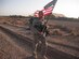 U.S. Air Force security forces 2nd Lt. Jason Sawyers, 838th Air Expeditionary Advisory Group, marches with the American Flag at Shindand Air Base, Shindand, Afghanistan, Sept. 11, 2011. Airmen from the 838th AEAG participated in a 24-hour ruck march in honor of the victims of the September 11 attacks. (U.S. Air Force photo by Master Sgt. Jason Brown)