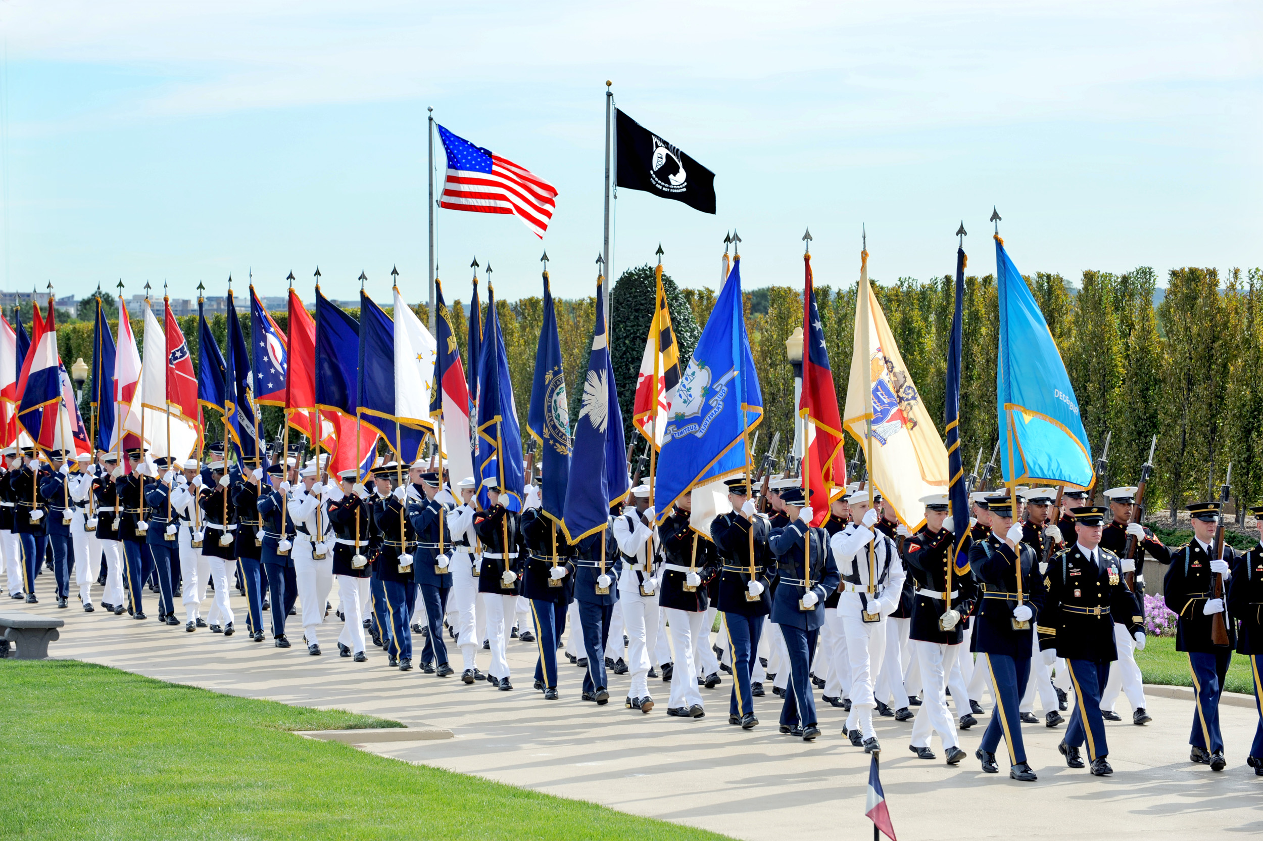 Joint service honor guards and flag bearers march onto the Pentagon's
