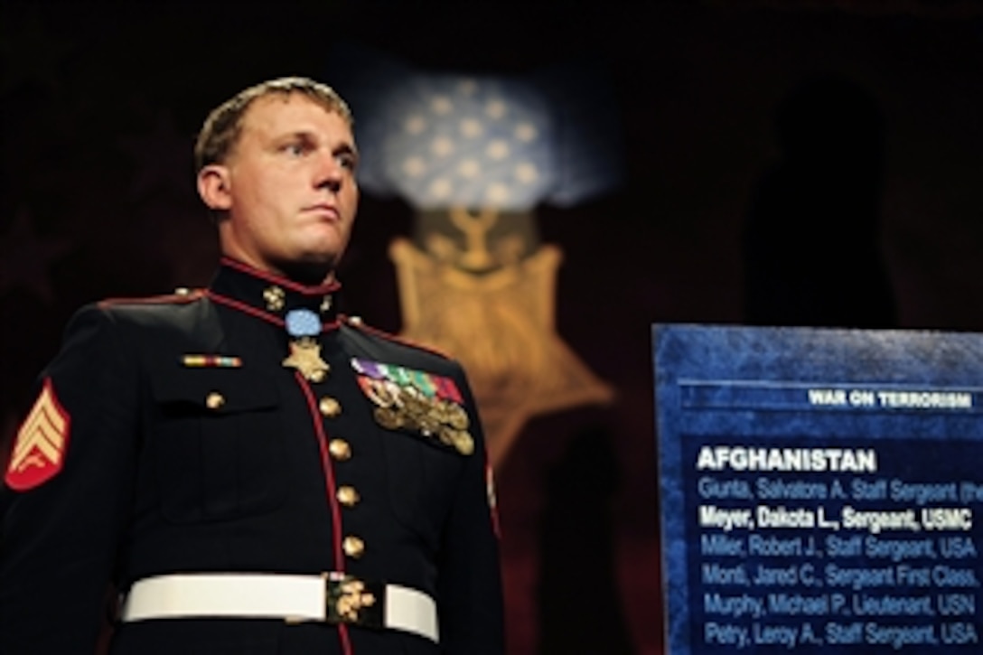 Medal of Honor recipient Marine Corps Sgt. Dakota L. Meyer stands next to a plaque bearing his name after he was inducted into the Pentagon's Hall of Heroes during a ceremony in the Pentagon, Sept. 16, 2011.