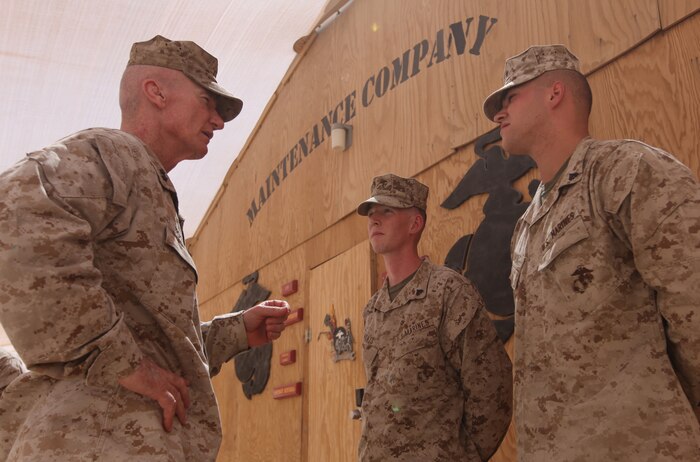 Maj. Gen. John A. Toolan (left), the commanding general of Regional Command Southwest, quizzes Cpls. Zachary Moats and Christopher Huber on the technical aspects of their job at the Intermediate Maintenance Activity lot, Sept. 17. As circuit card repair technicians with the 2nd Marine Logistics Group (Forward), the Marines were able to save $105,000 in equipment replacement costs and Toolan wanted to personally thank them for a job well done. (U.S. Marine Corps photo by Sgt. Justin J. Shemanski)