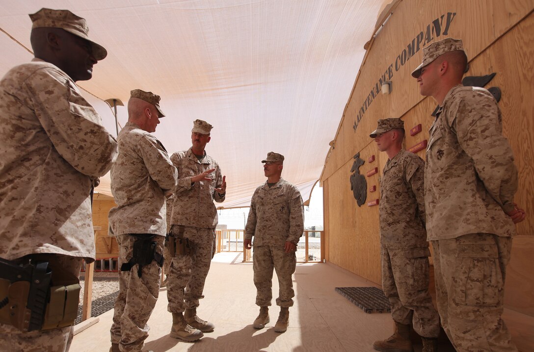 Col. Mark Hollahan (third from left), chief of staff for 2nd Marine Logistics Group (Forward), explains the capabilities of the Marines at the Intermediate Maintenance Activity lot to Maj. Gen. John A.Toolan, commanding general of Regional Command Southwest, during a visit to the compound aboard Camp Leatherneck, Sept. 17. Toolan paid Cpls. Zachary Moats and Christopher Huber a visit to thank them for their efforts in saving more than $105,000 in equipment repair costs in the scope of their duties as circuit card repair technicians. (U.S. Marine Corps photo by Sgt. Justin J. Shemanski)
