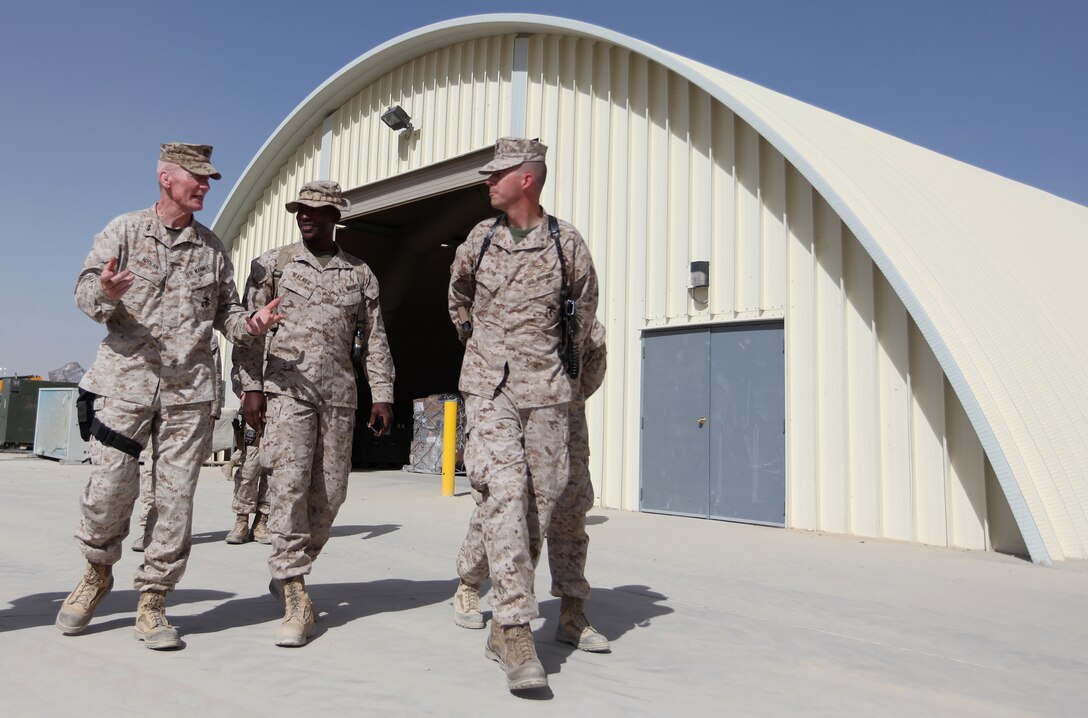 Maj. John Flynn (right), commanding officer of Headquarters and Service Company, 2nd Marine Logistics Group (Forward), escorts Maj. Gen. John A. Toolan, commanding general for Regional Command Southwest, through the grounds of the Camp Leatherneck Post Office, Sept. 17. Toolan spent the afternoon touring several of the facilities operated by 2nd MLG (FWD) personnel including the Intermediate Maintenance Activity lot and the Concussion Restoration Care Center. (U.S. Marine Corps photo by Sgt. Justin J. Shemanski)