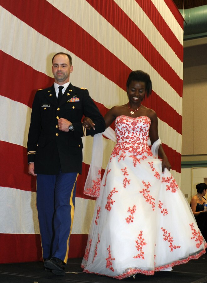 Sgt. Teresia Kamau (right), the training chief for the 8th Marine Corps District walks offstage during the 2011 Ball Gown Giveaway on Naval Air Station Fort Worth Joint Reserve Base in Fort Worth, Texas. During the joint service event, military escorts and models –including Kamau – put on a fashion show for military families before the families were given the opportunity to choose from hundreds of donated dresses. Kamau is the noncommissioned officer-in-charge of the inbound personnel section of Headquarters, 8th MCD. She was named the 8th MCD Marine of the Quarter for the third quarter and Marine of the Year for fiscal year 2011 for “exceptional initiative, positive attitude and diligent work ethic.”